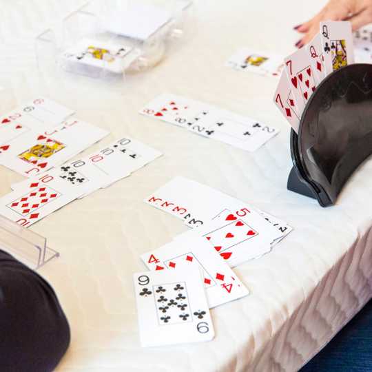 Group of people playing card game canasta 